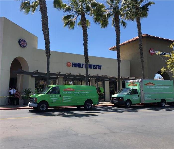 Storefront damaged by fire with SERVPRO truck in front. 