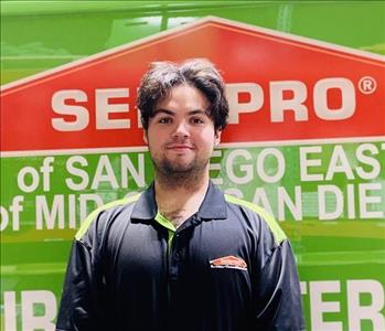 Man standing in front of a green background with SERVPRO logo.