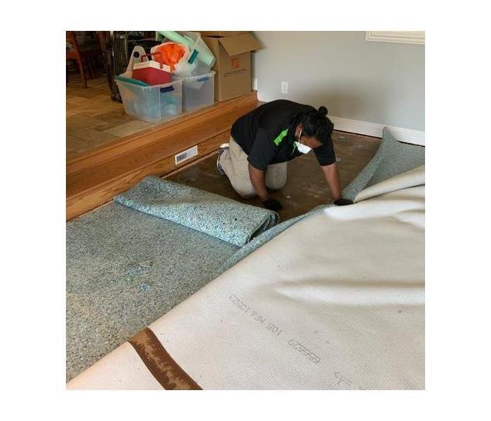 Technician removing damaged carpet. 