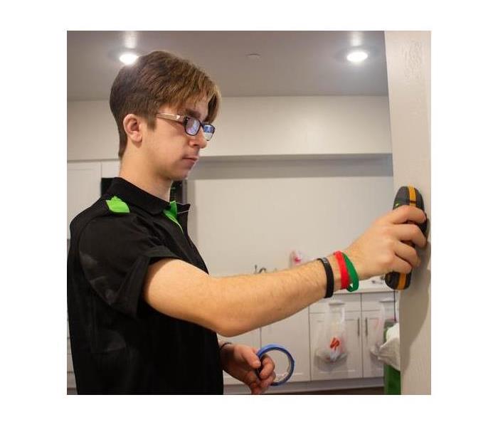 Technician inspecting walls for water content.