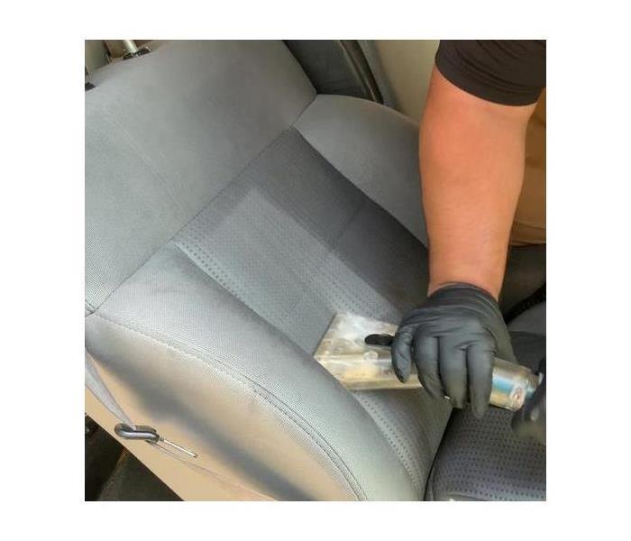 Technician cleaning car upholstery. 